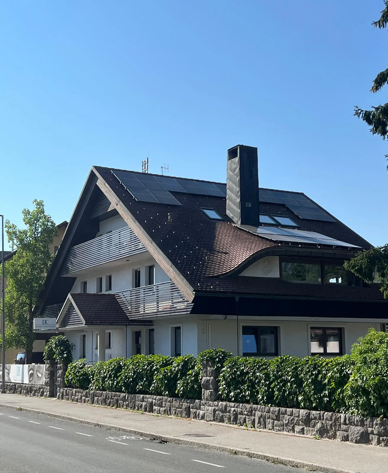 Exterior of the house on Prešernova cesta 15 — the penthouse is the top floor with solar panels, skylights and a private balcony